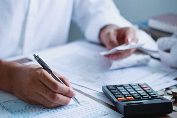Man,Hand,Filling,Us,Tax,Form.,Tax,Form,Us,Business