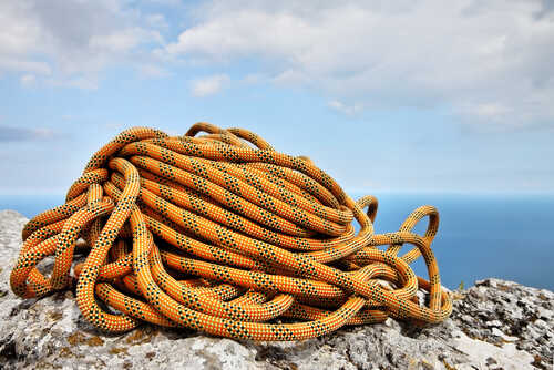 Climbing,Rope,Coiled,Up,And,Placed,On,The,Rock