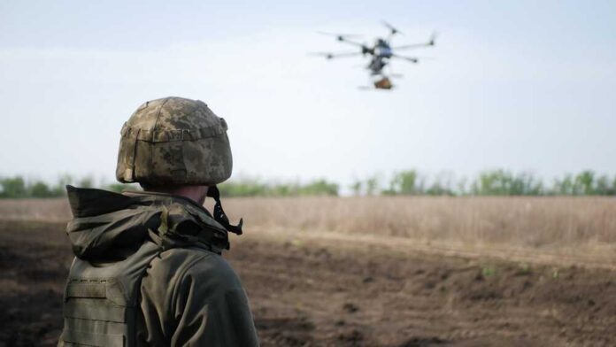 A,Soldier,In,Camouflage,Observes,A,Drone,Hovering,Above,An