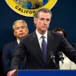 Billion-Dollar UK Partnership: Treason or Brilliant? Person speaks at podium with California seal behind.