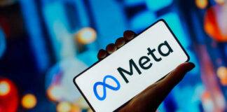 Hand holding phone displaying Meta logo