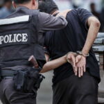 Police officer arresting a suspect in handcuffs in an urban environment