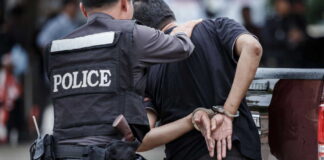Police officer arresting a suspect in handcuffs in an urban environment