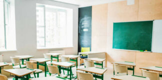 Empty classroom with desks facing a chalkboard