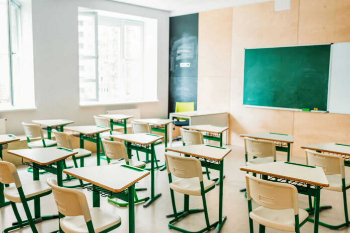 Empty classroom with desks facing a chalkboard