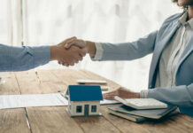 Two people shaking hands over a contract