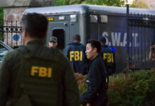 FBI and SWAT team gathered near vehicle.