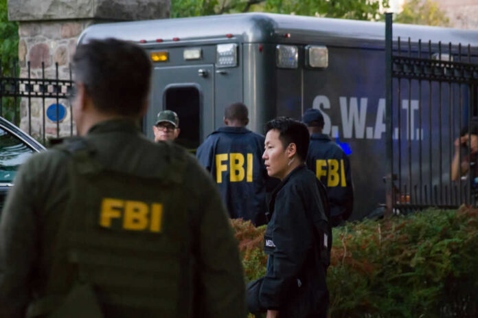 FBI and SWAT team gathered near vehicle.