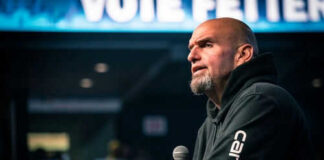 Man speaking into microphone on stage.