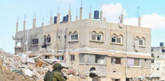Soldier crouching near building in a wartorn area