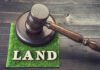 Gavel on grass with the word land