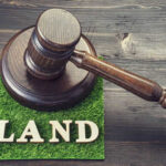 Gavel on grass with the word land