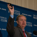 Man holding phone at National Press Club event