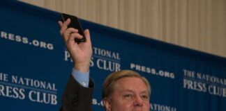 Man holding phone at National Press Club event