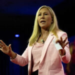 CNN Promotes Greene Amid MAGA Fallout Woman speaking on stage wearing pink blazer