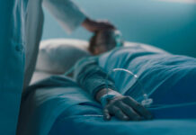 A medical professional attending to a patient in a hospital bed