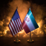 Flags of the United States and Iran displayed on stands with a smoky background