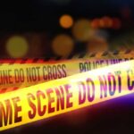 MYSTERIOUS Attack at Strategic Military Hub Yellow police tape marking a crime scene with blurred lights in the background