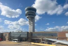 View of an airport control tower and terminal from an airplane window