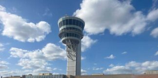 View of an airport control tower and terminal from an airplane window