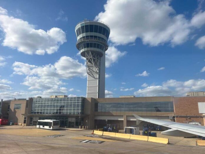 View of an airport control tower and terminal from an airplane window