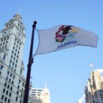 Illinois Law Shields Kids from Eviction Records Illinois state flag waving in front of historic buildings against a blue sky