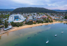 Beachfront town with buildings boats and surrounding hills