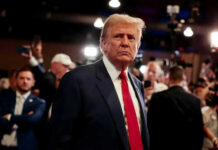 Man in suit with red tie at crowded event