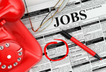 $30 Wage Battle: Experts Warn of Job Apocalypse Job classifieds with phone, pen, and glasses. Job