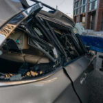 Damaged car with smashed rear window on street