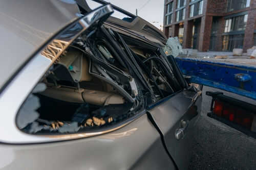 Damaged car with smashed rear window on street