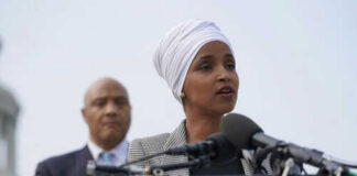Two people speaking at a podium with microphones