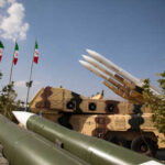 Military missiles displayed outdoors with Iranian flags in the background
