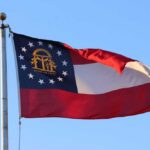 Georgia state flag waving against a clear blue sky