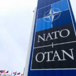 NATO sign with flags in the background