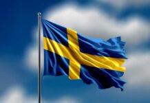 Waving flag of Sweden against a blue sky