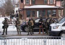 Law enforcement officers in tactical gear at a crime scene in winter