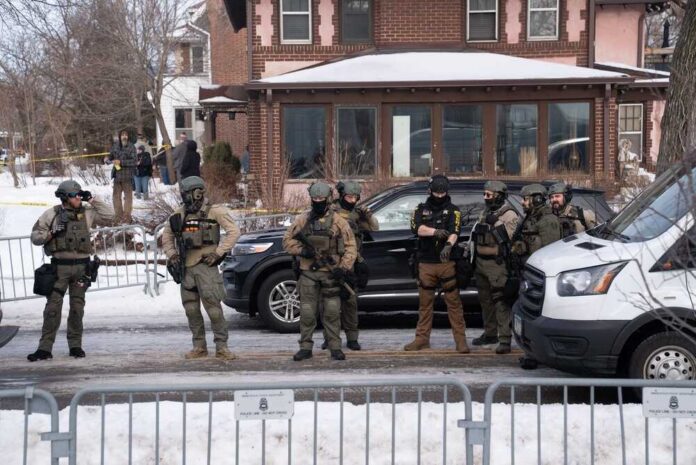 Law enforcement officers in tactical gear at a crime scene in winter