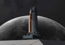 A rocket on a launch pad with the moon in the background