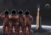 NASA’s Artemis II Crew Faces 40-Minute Isolation Four astronauts in orange suits standing in front of a rocket with the moon in the background