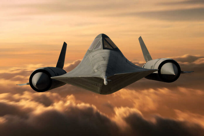 A stealth aircraft flying above clouds during sunset