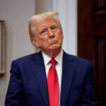 Trump’s Southern Spear SINKS Narco Boat Person in suit and red tie standing indoors