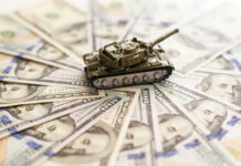 Toy tank on spread out dollar bills