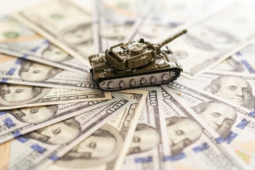 Toy tank on spread out dollar bills