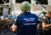 War crimes investigator in helmet at a damaged site