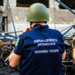 War crimes investigator in helmet at a damaged site