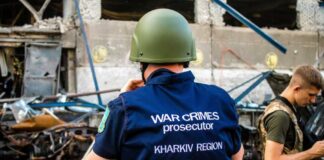 War crimes investigator in helmet at a damaged site
