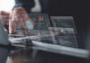 AI Influencers Booming—But At What Cost? Hands typing on laptop with AI and code overlays