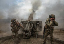 Overnight Bombshell: NATO on Edge Over Belarus Drill Soldiers fire a field howitzer as smoke and dust rise around them