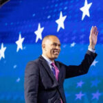 Man in suit waving against starry blue background